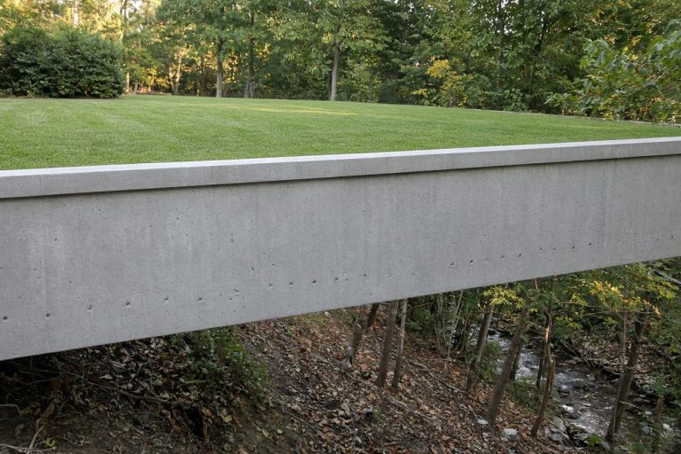 Finished concrete wall holding a level yard above a creek bank, Retaining Walls in Chesterton