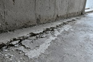 Worn basement floor edge with surface scale near a wall — Concrete Basements in St. John