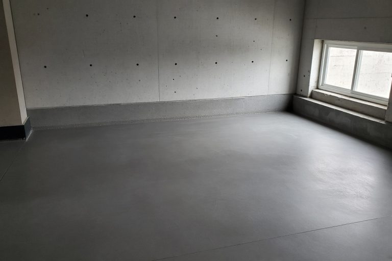 Smooth finished basement floor meeting a straight concrete wall — Concrete Basements in St. John