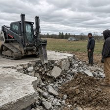 Crew breaking a thick barn slab on an acreage lot — Concrete Demolition Companies in Lowell