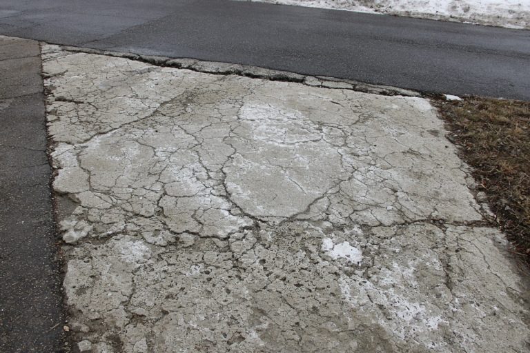 Scaled cracked driveway apron with salt residue in winter — Concrete Driveways in Gary