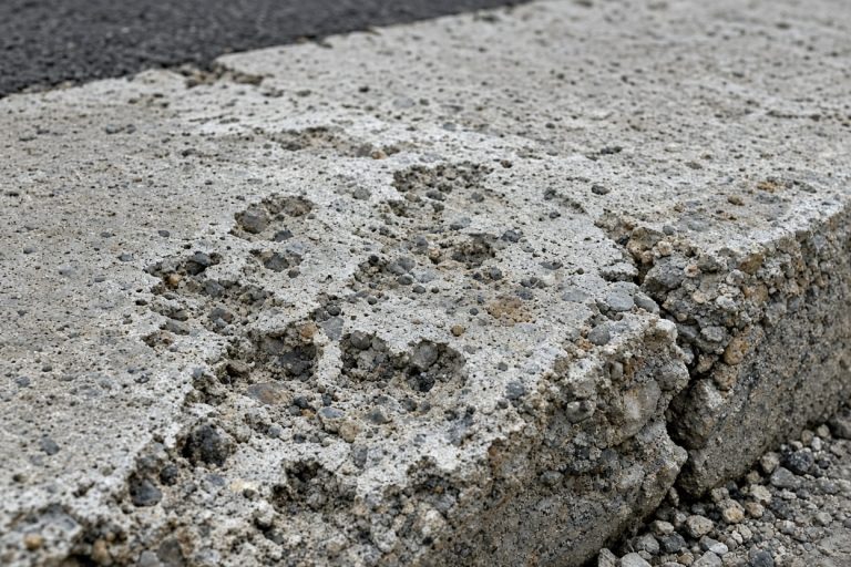 Pitted and scaled concrete near a driveway street edge — Concrete Driveways in Lowell