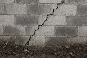Stair-step crack in a block wall with clay soil at the base - Concrete Foundations in Merrillville