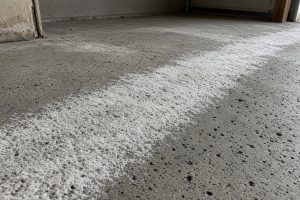 Pitted garage slab with white salt crust in tire paths — Concrete Garage Floors in Hobart