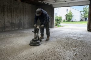 Crew grinding a pitted garage floor before overlay — Concrete Overlays in Calumet City