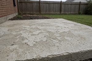 Worn patio surface with scaling and solid edges — Concrete Overlays in Lansing