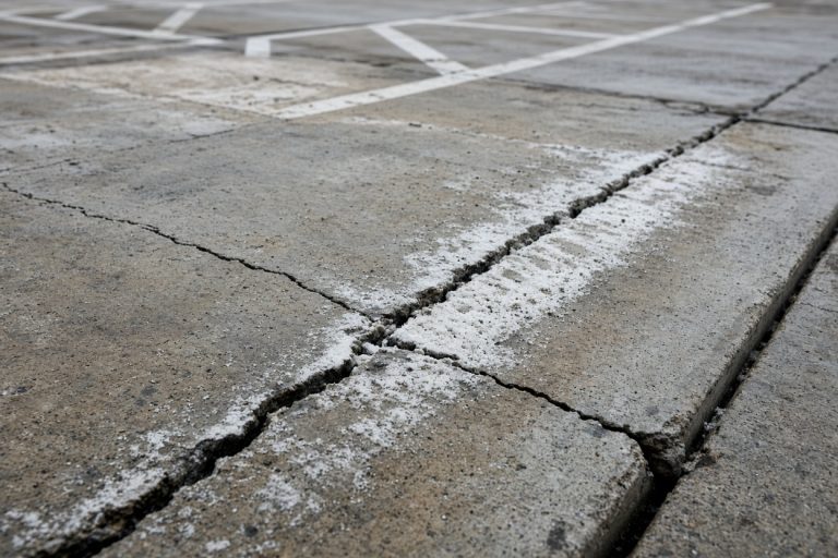 Cracked drive aisle with salt residue along a joint — Concrete Parking Lots in East Chicago