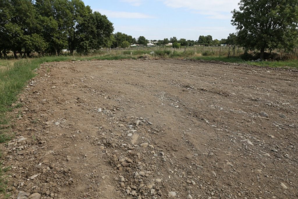 Bare dirt after an old pad was hauled off a farm lot — Concrete Removal in Hebron