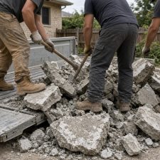 Crew breaking and loading an old concrete patio onto a truck — Concrete Removal in Porter
