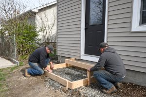 Crew setting wood forms for new front steps — Concrete Steps in Portage