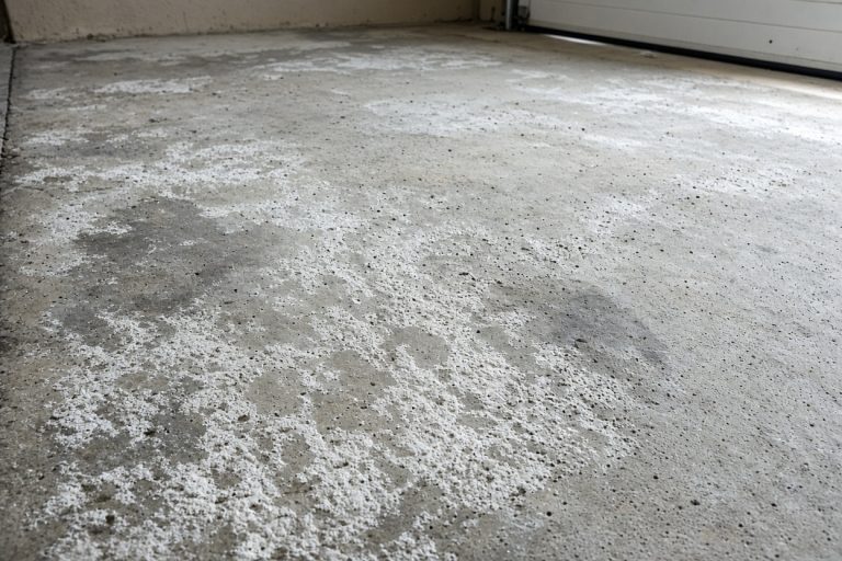 White salt crust and pitting on a bare garage slab — Epoxy Flooring in Highland