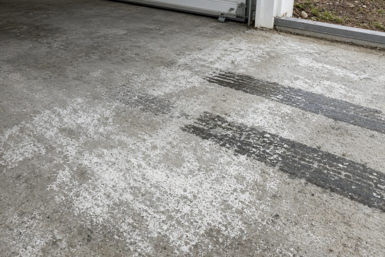White salt crust and wet tire marks on bare garage concrete — Epoxy Flooring in South Haven