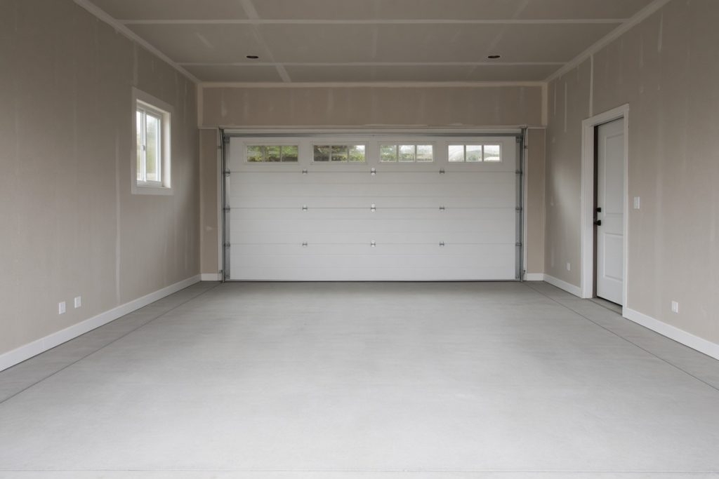 Newly finished interior garage slab looking toward the overhead door — Garage Floors in Hebron