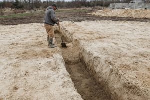 Open footing trench cut through loose sand — Concrete Foundations in Portage