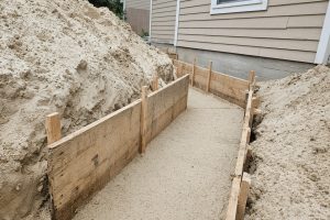 Compacted sand in a footing trench before the pour — Concrete Foundations in Porter