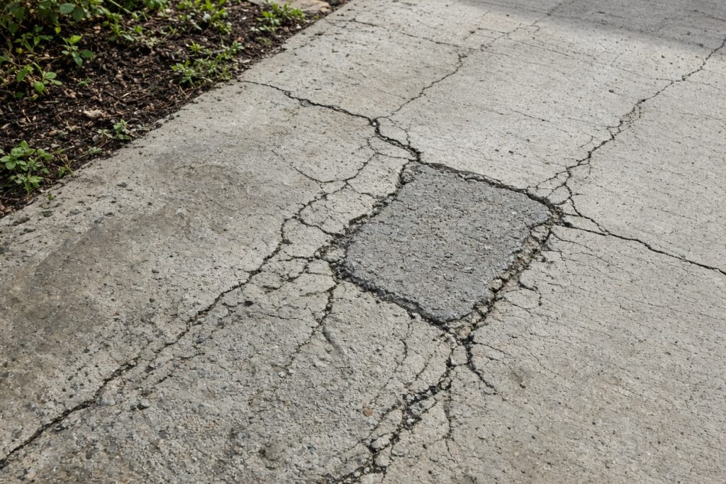 Cracked ranch walk with a failed surface patch — Residential Concrete in Portage