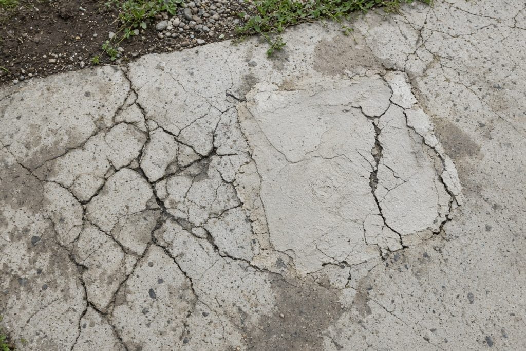 Cracked ranch walk with a failed surface patch — Residential Concrete in Portage